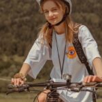 Ride-Sharing - A woman riding a bike on a dirt road