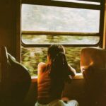 Train Routes - Unrecognizable woman riding train and looking out window