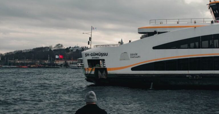 Ferry Services - A man sitting on a bench looking out at the water