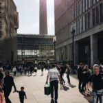 Shopping Districts - Man in Black Crew-neck T-shirt Walking Near Building