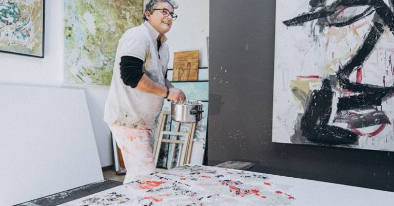 Artist Studios - A man painting in an art studio with a large painting