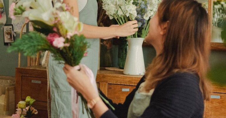 Craft Markets - Side view of glad colleagues preparing blooming floral decorations while working in stylish florist workshop