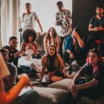 Multicultural Events - Group of multiethnic people gathering around female speaker in studio